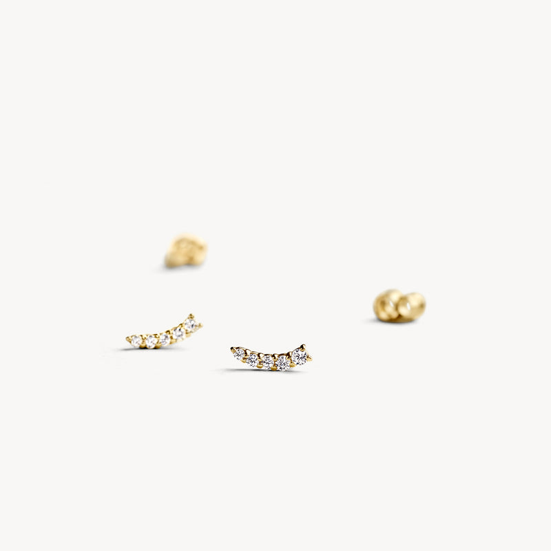 Puces d'oreilles en or jaune 14k avec de petites Zircones rondes en forme d'arche légère.