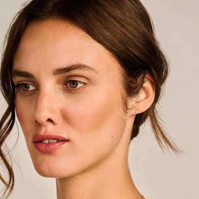 Oorknop van 14k geelgoud met gladde, ronde vorm en kleine afmetingen.