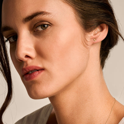 Oorknopjes van 14k geel goud met subtiel glanzende afwerking, klein en rond van vorm.