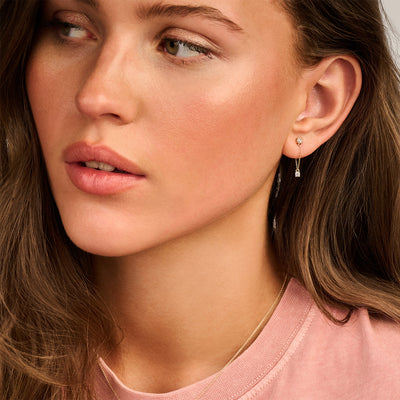 Oorknopje van 14k geelgoud met fijne schakel en kleine zirkonia steen.