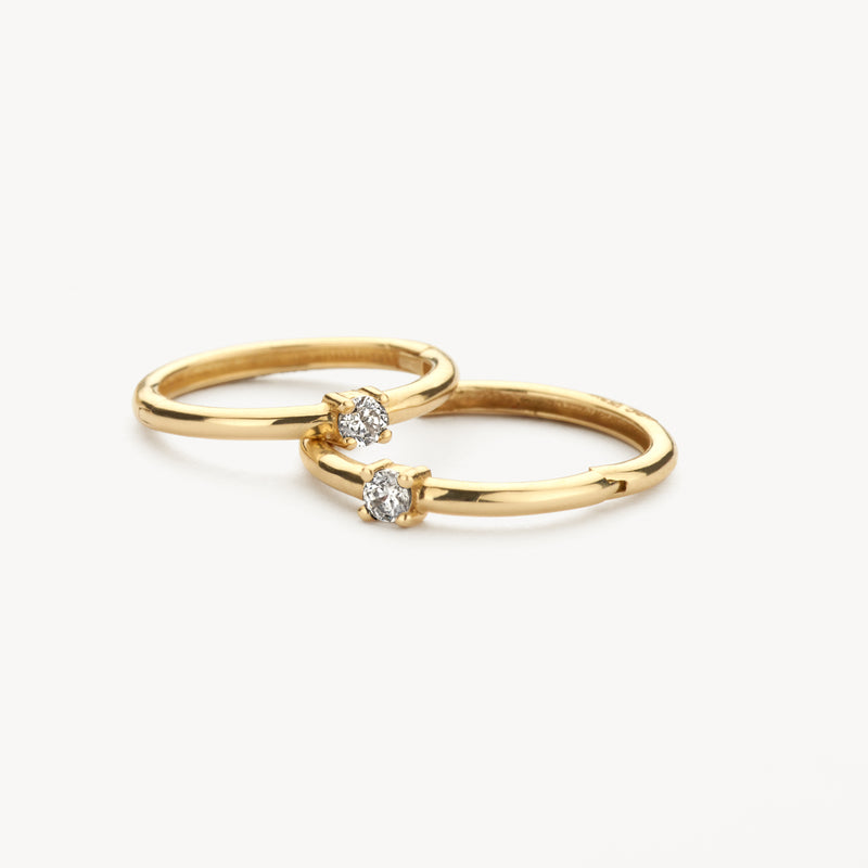 14k geelgouden oorringen met enkele zirkonia steentjes, glanzend en minimalistisch design.