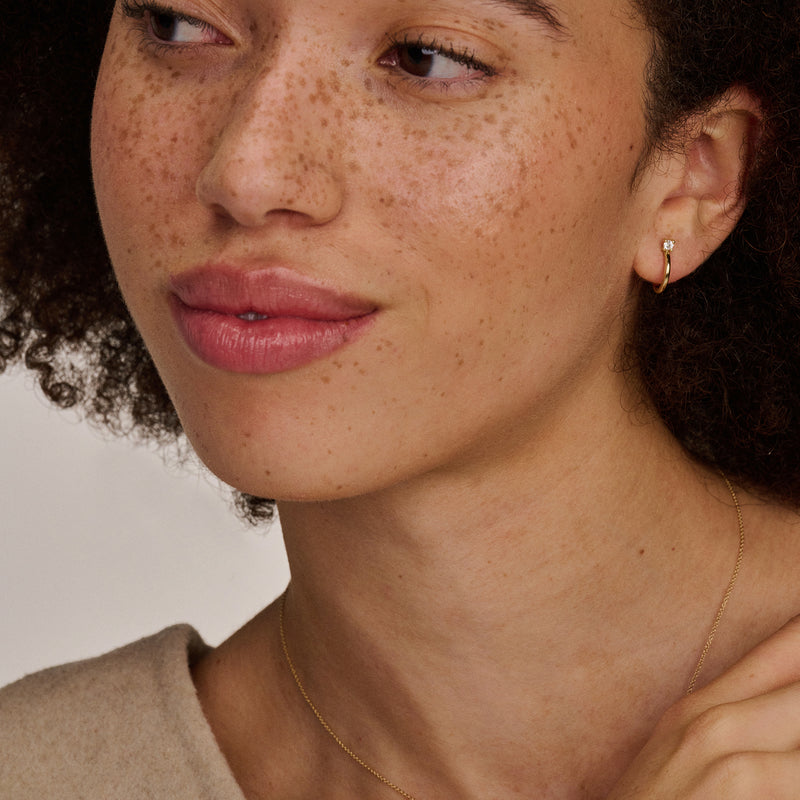 Bicolor oorringen van 14k rosé en wit goud met fonkelende zirkonia detail.