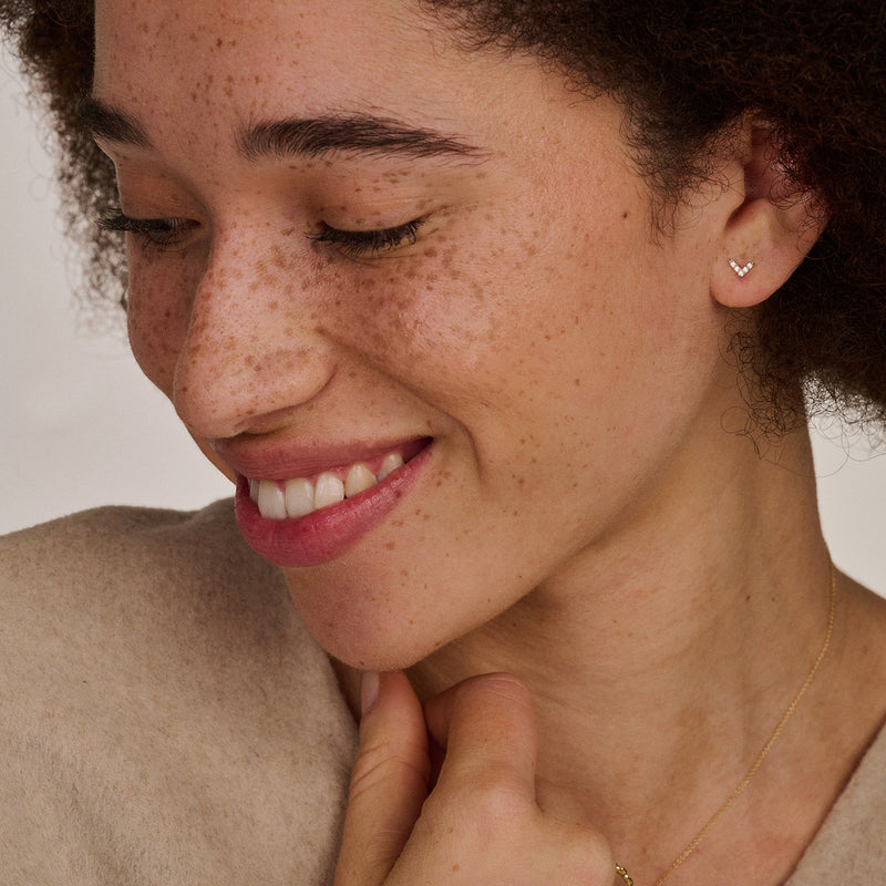 vrouw met 14k gouden oorknopjes in V vorm