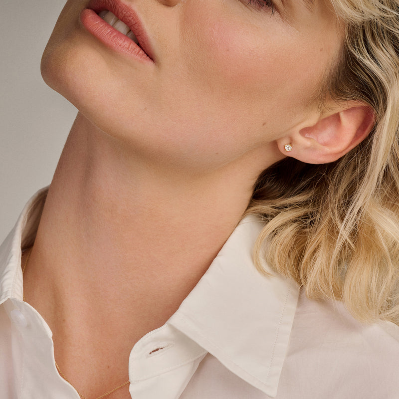 Oorstekers van 14k goud met kleine ronde diamant in minimalistisch ontwerp.