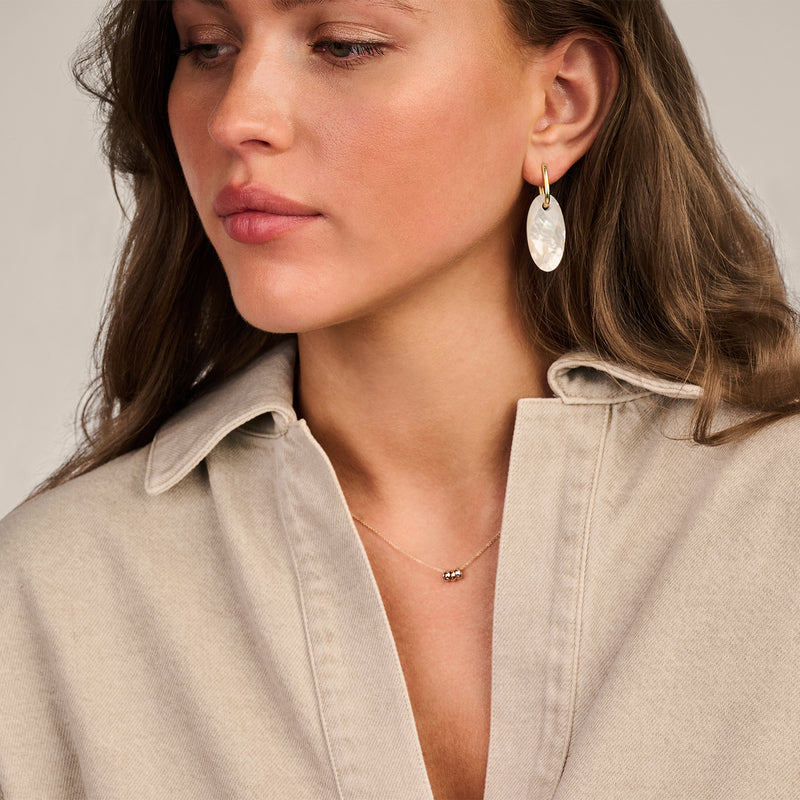 Bicolor ketting met hanger in 14k goud, wit goud en rosé goud, gedragen door vrouw.