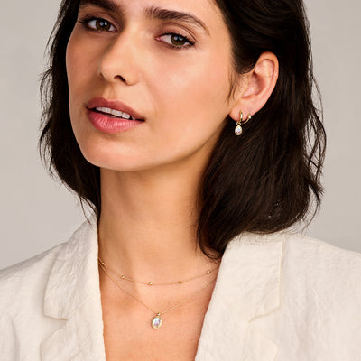 Fijne ketting van 14k geelgoud met een klein rond hangertje aan een dunne schakelketting.