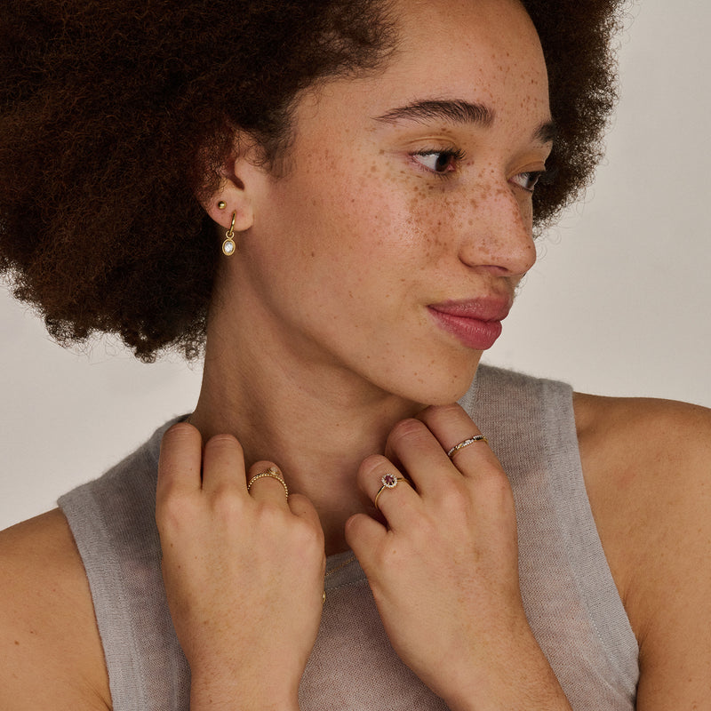 Bague en or 14k avec améthyste en petite taille, portée à la main gauche .
