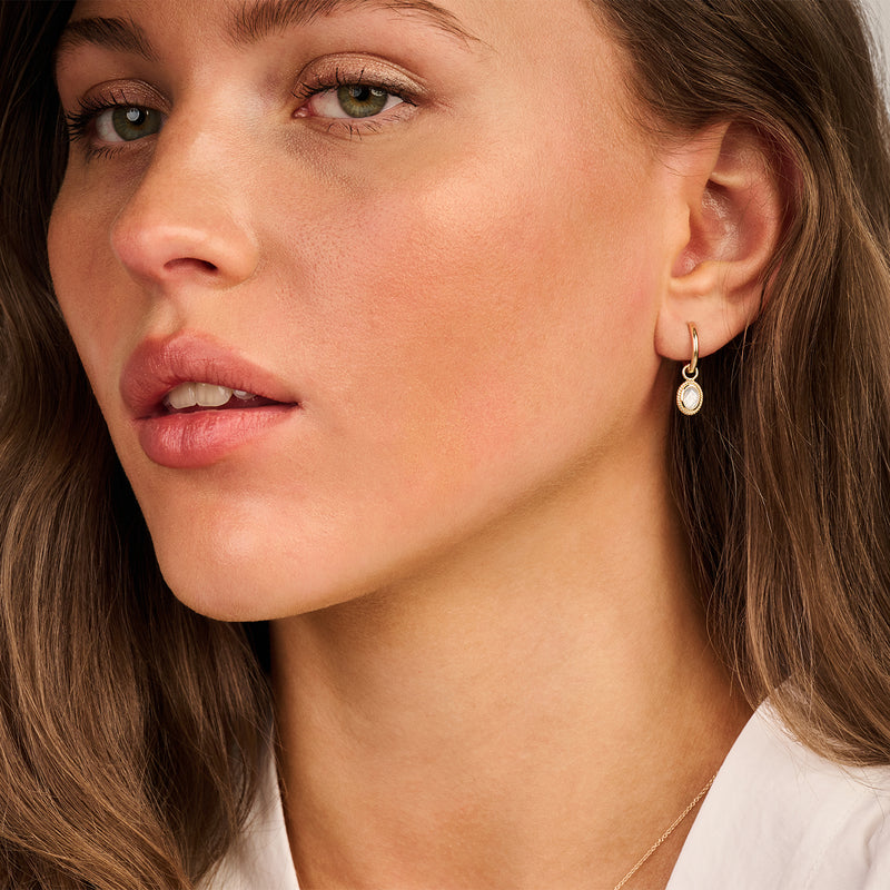 14k geelgouden oorring met parelhangertje en fijne details.