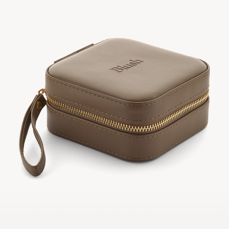 Quadratische Reisetasche aus Nussbaumnappa mit goldenem Reißverschluss und Handschlaufe.