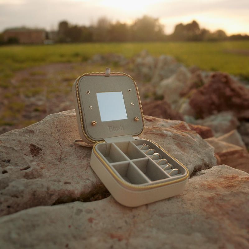 Graue Nappa-Reisetasche mit Facheinteilung und Spiegel auf Felsen außen.