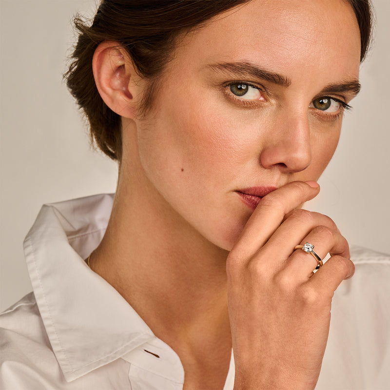 14k geelgouden solitair ring met labdiamant en gerecycled goud op vrouwenshand.