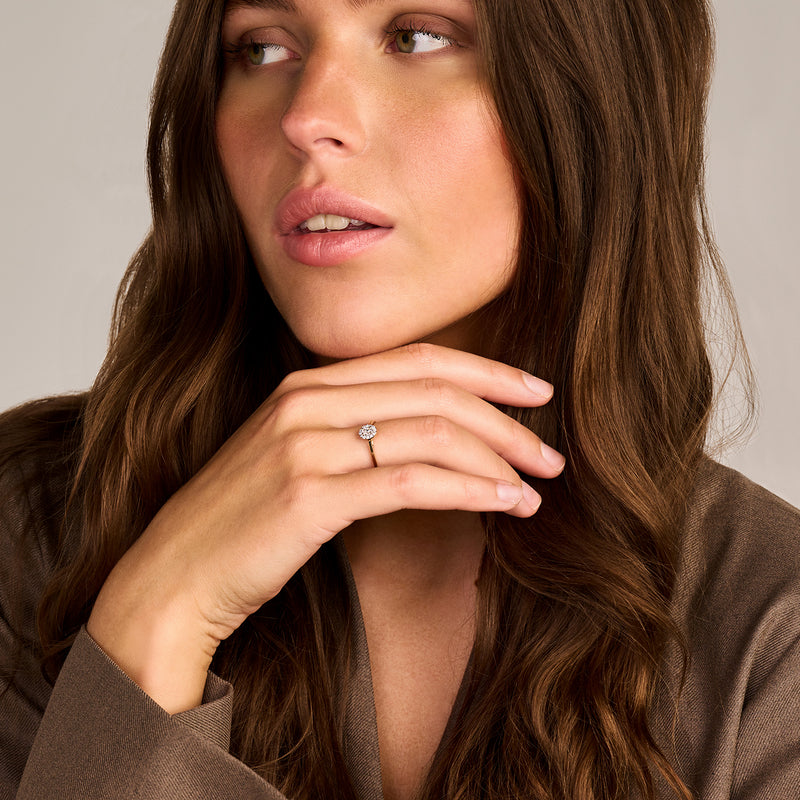 14k geelgouden ring met kleine Lab Diamonds op vrouwelijk hand met bruine outfit.