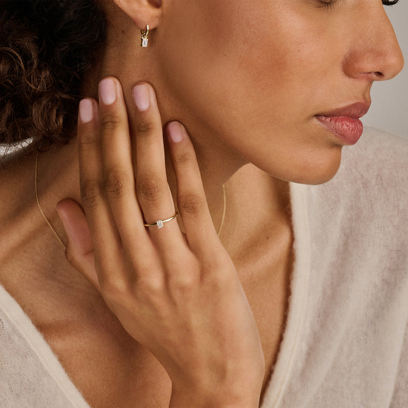 14k Wit goud solitair ring met kleine lab diamant op vrouwelijke hand.