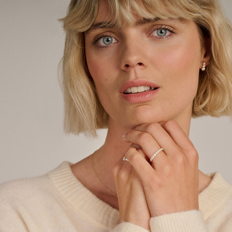 14k geelgouden ring met kleine labdiamanten, gedragen aan wijsvinger.