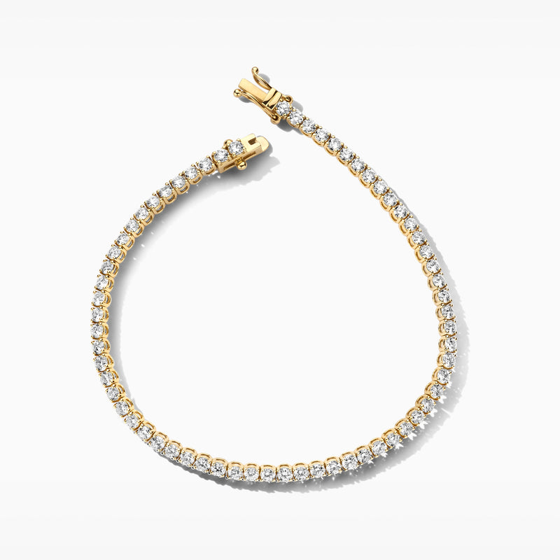 Armband van 14k geel goud met ronde labdiamanten en stevige sluiting.