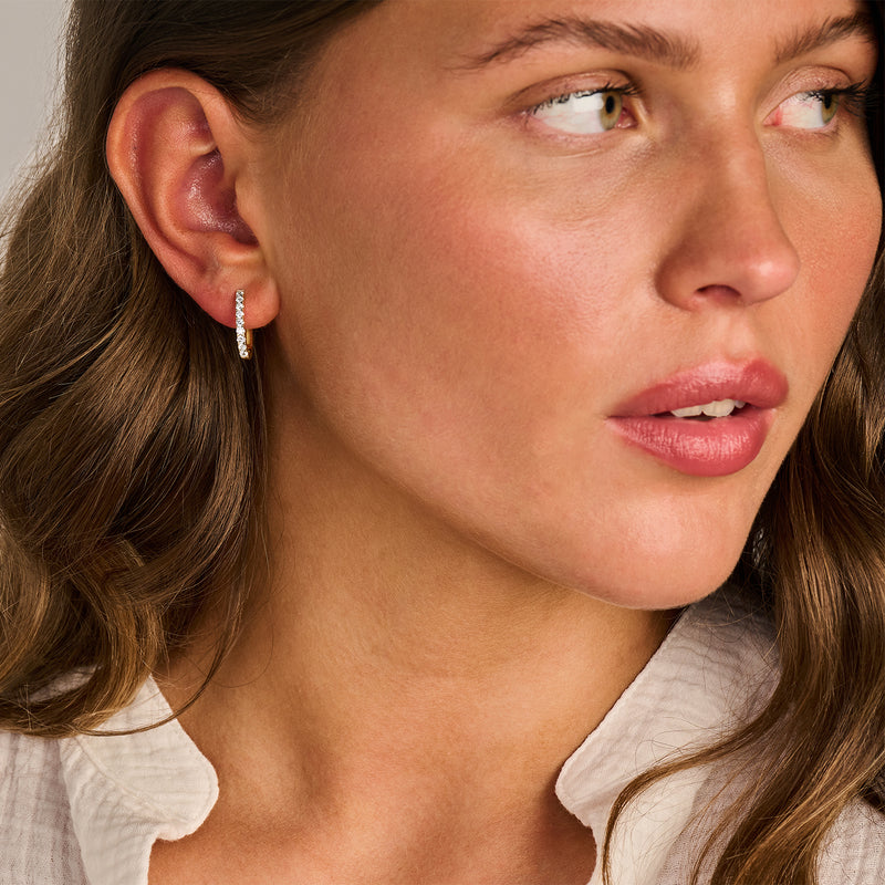 Oorringen met Lab Diamonds in 14k geel goud bij oor, gerecycled goud detail.