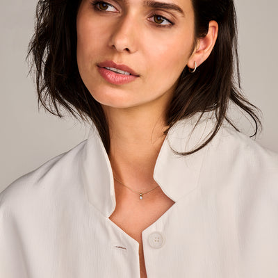 14k geelgouden oorringen met Lab Diamonds aan model met witte blouse.