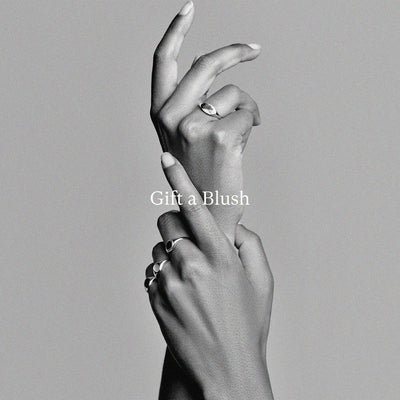 Hand met drie ringen van 14k Goud, 14k Wit goud en 14 Rosé goud, minimalistisch design.