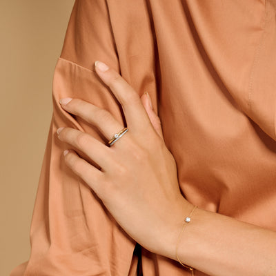 Bicolor ring van 14k geel en wit goud met zirkonia, gedragen aan ringvinger.