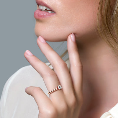 14k rosé goud solitair ring met zirkonia op slanke band aan vinger.