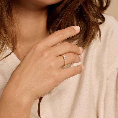 Bicolor ring met 14k geel goud en witte zirkonia op wijsvinger.