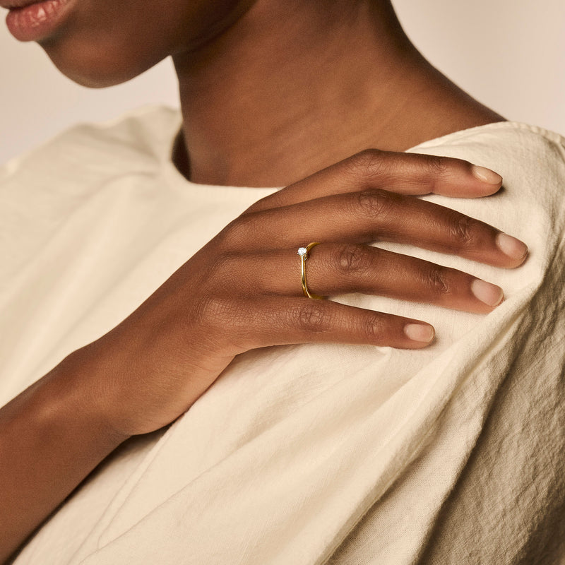Bicolor gouden ring met zirkonia in 14k geel goud, gedragen aan ringvinger.