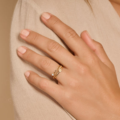 14k goud aanschuifring met kleine sprankelende details op een hand.