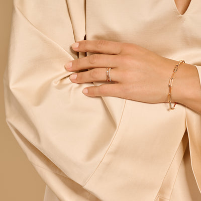 14k roségouden solitair ring met fijne band en kleine diamantzichtbaar op gestileerde hand.