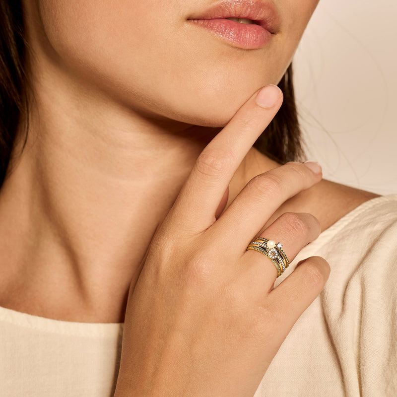 14k geelgouden ring met kleine witte parel, smal en glanzend design.