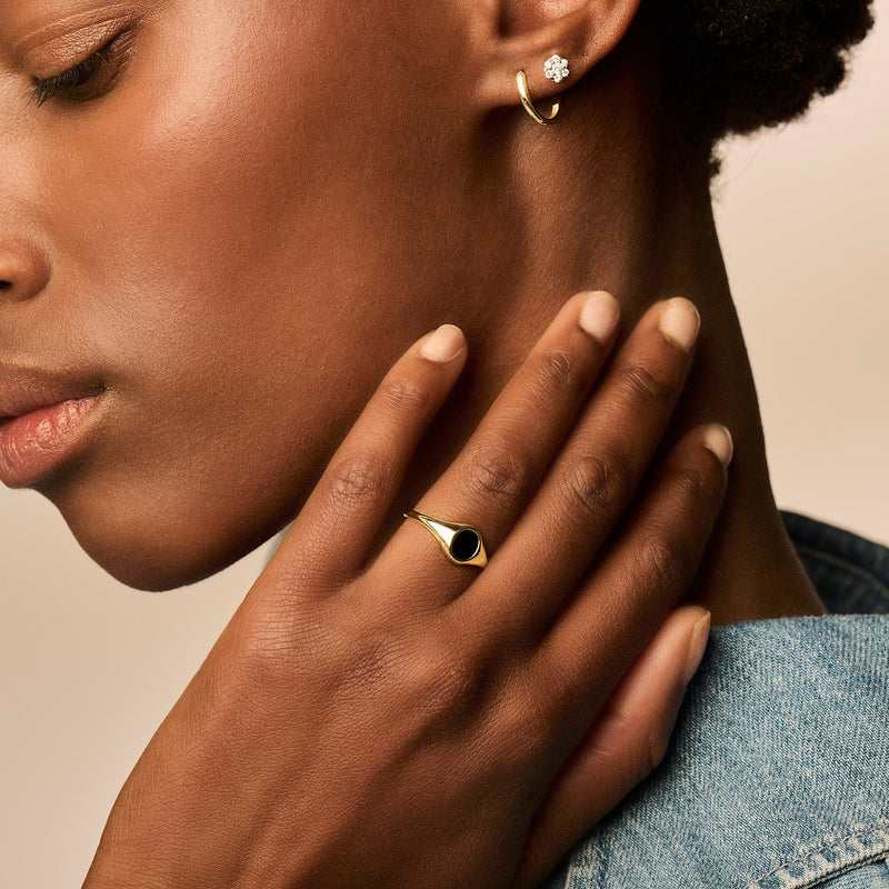 Zegelring van 14k geelgoud met ovale onyx steen, draagbaar aan wijsvinger.