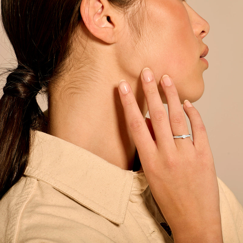 14k wit goud ring met diamanten band gedragen aan vinger naast gezicht vrouw.