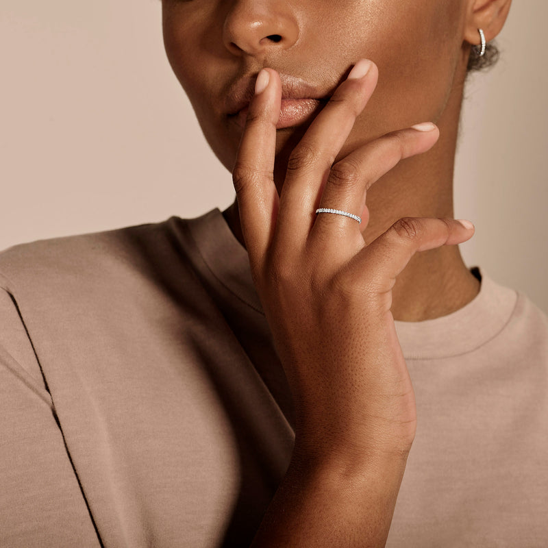 Fijne diamanten ring van 14k wit goud gedragen aan wijsvinger met minimalistisch design.