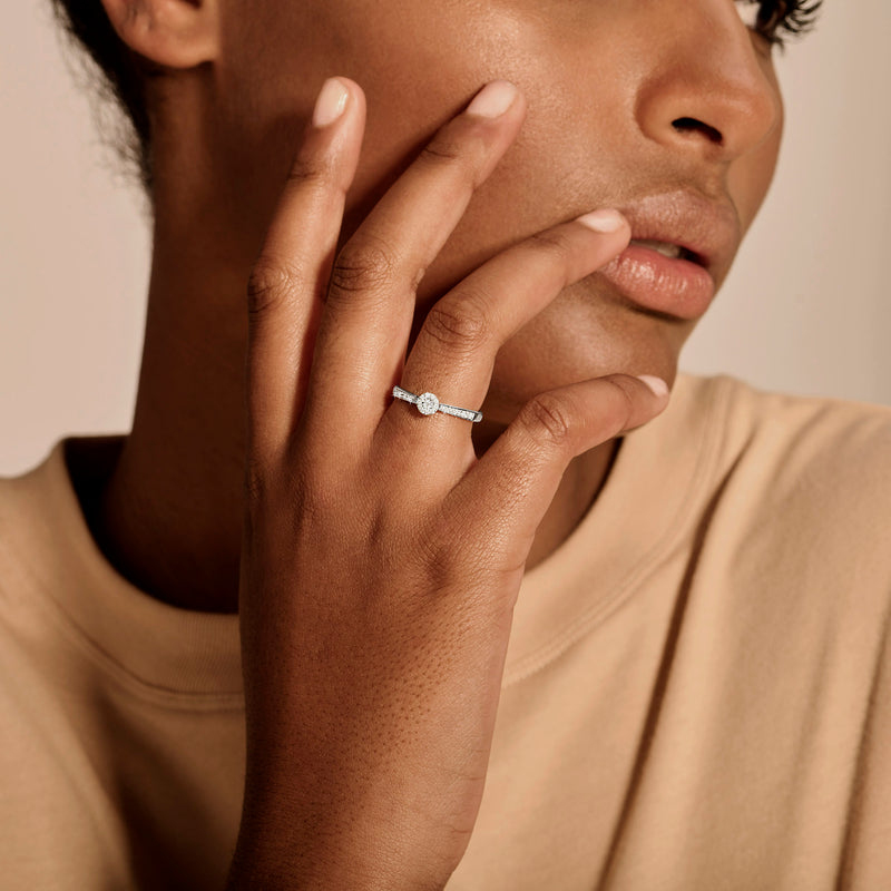 14k wit gouden ring met kleine diamant op slanke band zichtbaar aan linkerhand.