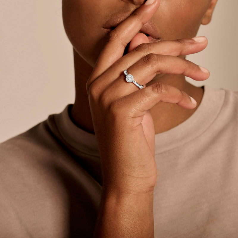 Zilverkleurige diamanten ring in 14k wit goud met ronde centrale diamant op hand.