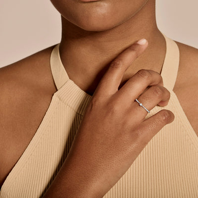 Fijne diamanten ring van 14k wit goud met subtiele glans aan hand van vrouw.