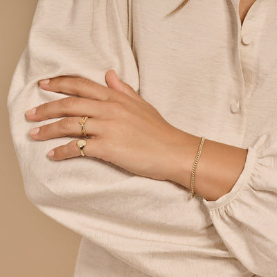 14k geelgouden fijne schakel armband subtiel om pols in naturel lichte blouse.