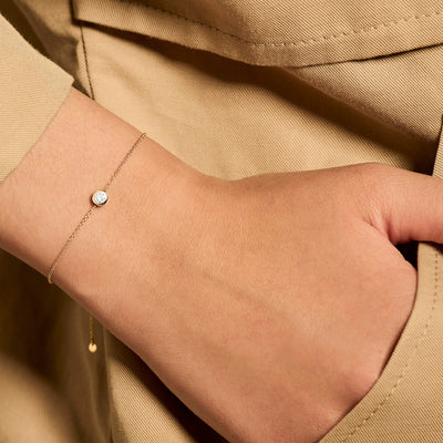 Delicate bicolor armband van 14k wit en geel goud met een enkele zirkonia steen.
