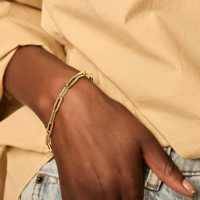 Armband van 14k geel goud met grove schakels aan pols.