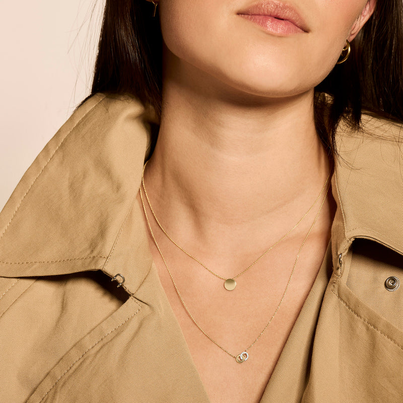 Dubbele ketting met fijne 14k geelgouden kettingen en ronde hangers in geel en wit goud.