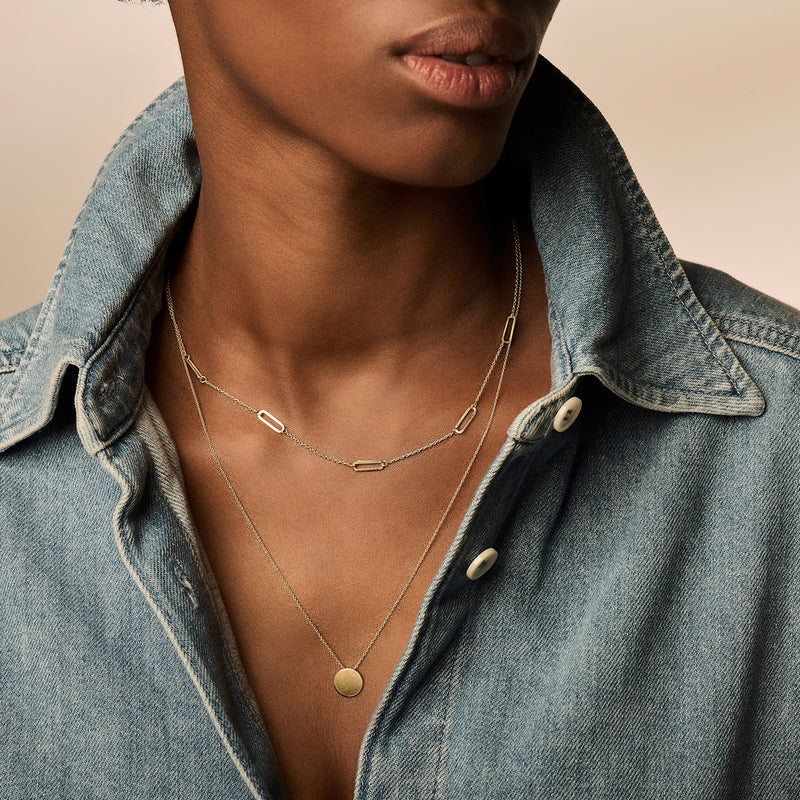 14k geelgouden ketting met grove schakels en fijne schakelketting met rond hangertje.