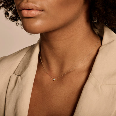 Delicaat diamanten collier in 14k geel goud met fijne schakel en kleine diamant.