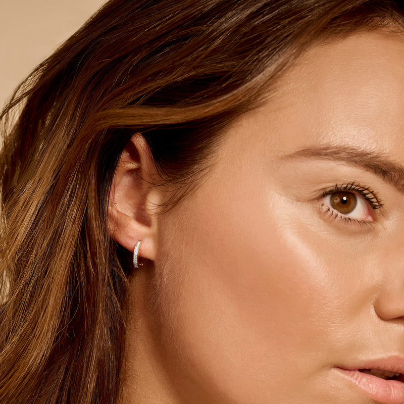 Bicolor oorringen van 14k geel en wit goud met fonkelende zirkonia's, close-up oorzicht.