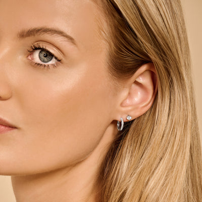 Oorring van 14k wit goud met kleine zirkonia studs en gladde ringvorm.