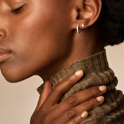 14k wit goud oorring met kleine zirkonia aan oorlel.