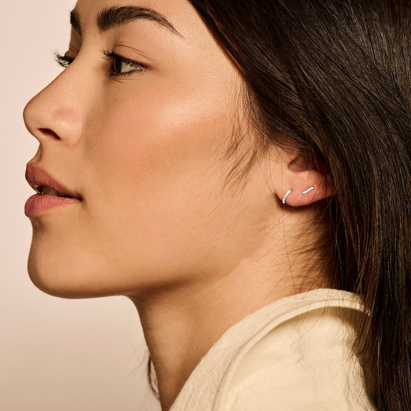 14k wit goud oorknopje met subtiele zirkonia detail aan oor.
