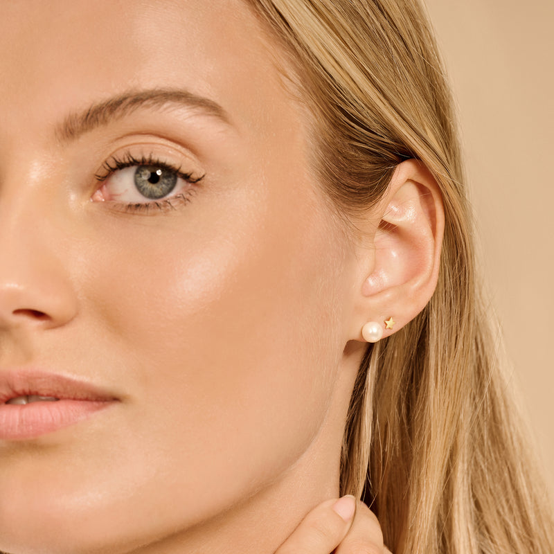 Clous d'oreilles en or jaune 14k avec une forme ronde lisse sur le rabat de l'oreille.