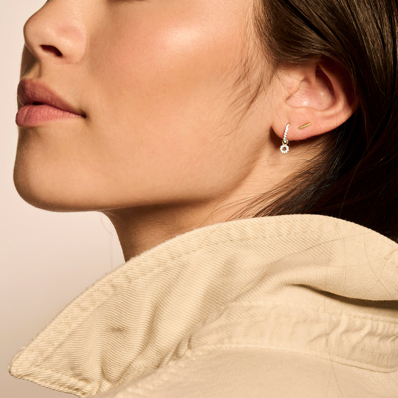 Oorknop 14k bicolor goud met wit en rosé goud, subtiele ronde vorm, gedragen aan oorlel.