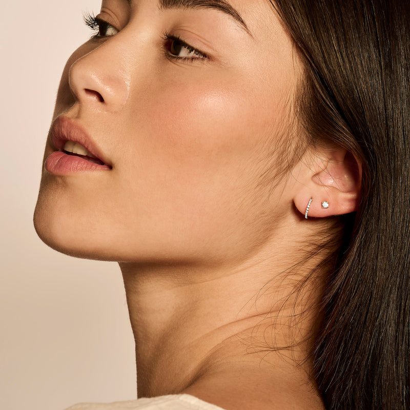 Anneaux d'oreilles en or jaune 14k avec Zircone subtilement portée au lobe de l'oreille.