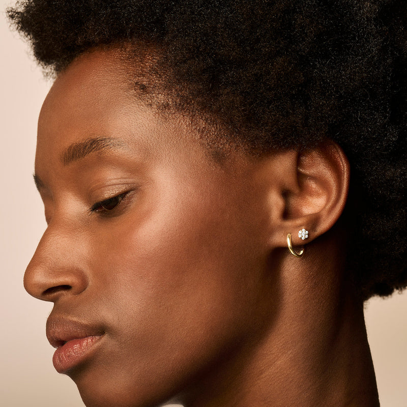 14k Geelgouden oorring met subtiel design gedragen aan linkeroor.