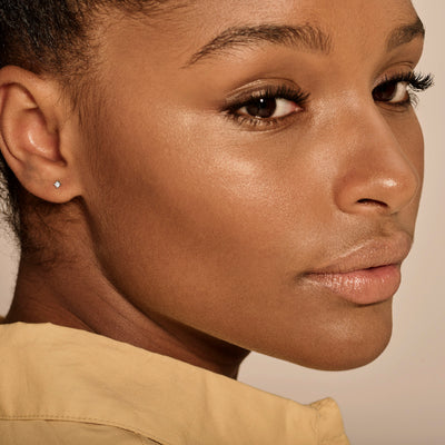 14k wit goud oorknop met briljante diamant in close-up zichtbaar in oor.